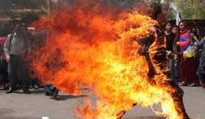 A Tibetan exile runs as he set fire to himself in New Delhi during a protest